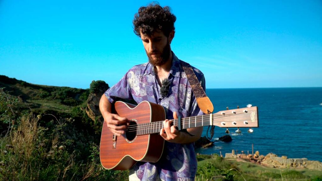 Cantante con su guitarra en la costa de Cantabria. Videoclip Pirio Guia 